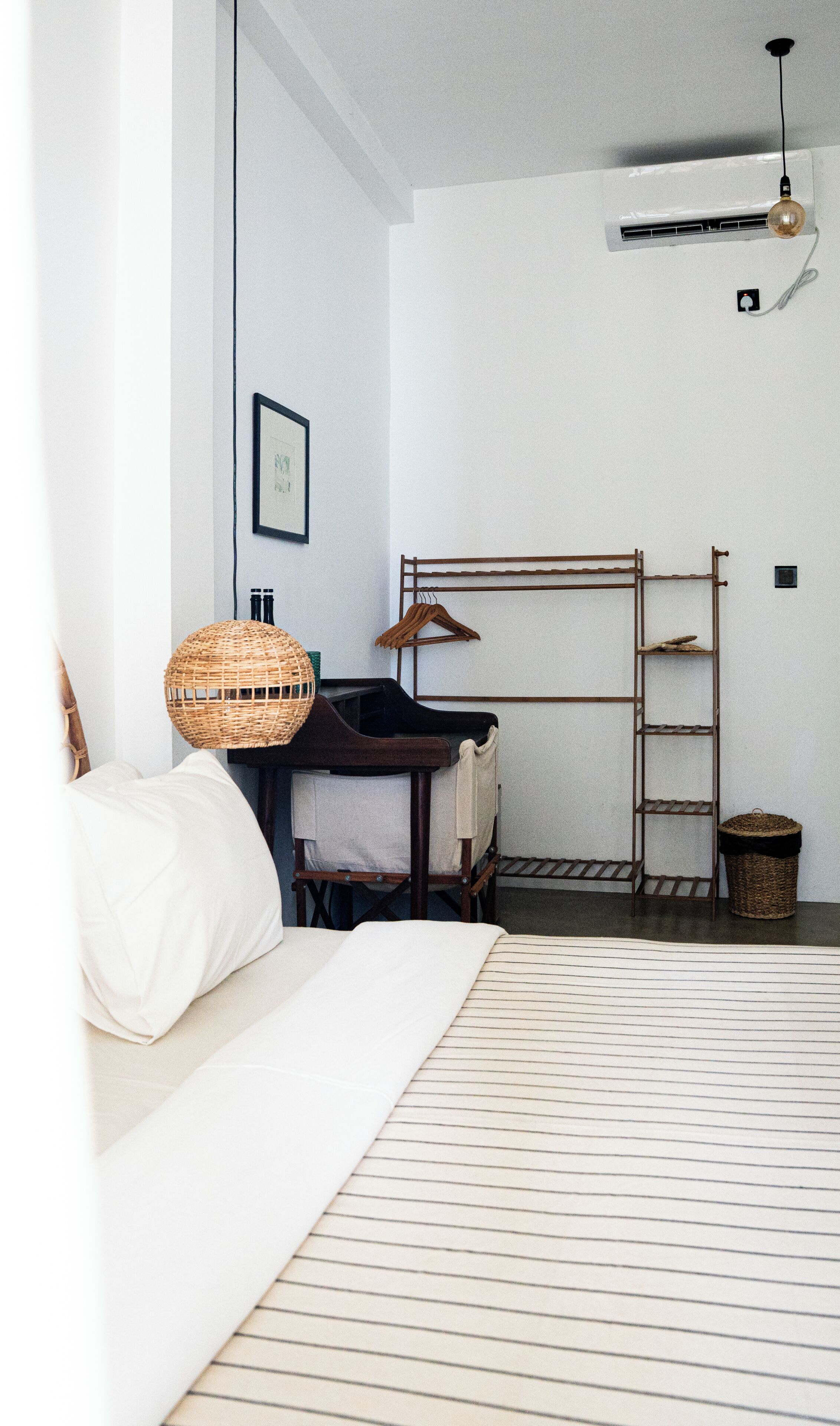 Ein Schlafzimmer mit einem Bett, einer Hängelampe, einer Leiter und einer Wand-Klimaanlage.