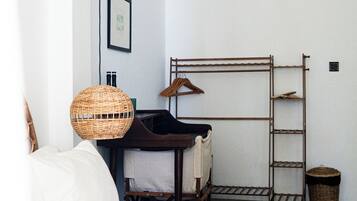 A bedroom with a bed, a hanging lamp, a ladder, and a wall-mounted air conditioner.