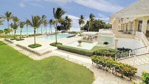 Un complexe hôtelier doté d’une piscine, de palmiers et d’un bâtiment avec un escalier.
