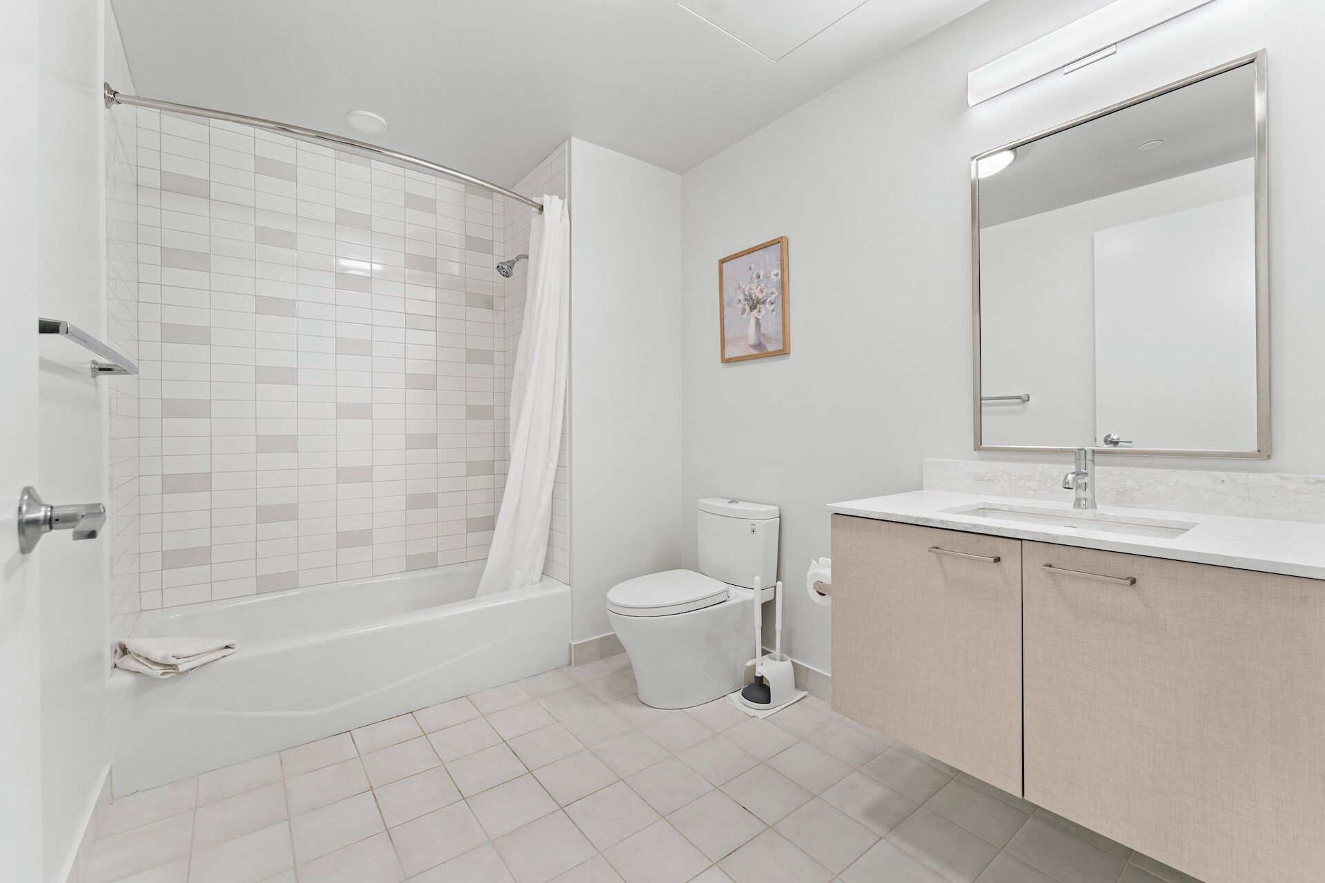 A modern bathroom with a shower, toilet, sink, and cabinet.
