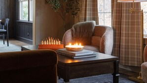 Ein gemütliches Zimmer mit Schachbrett, einer Kerze und einem bequemen Sessel.