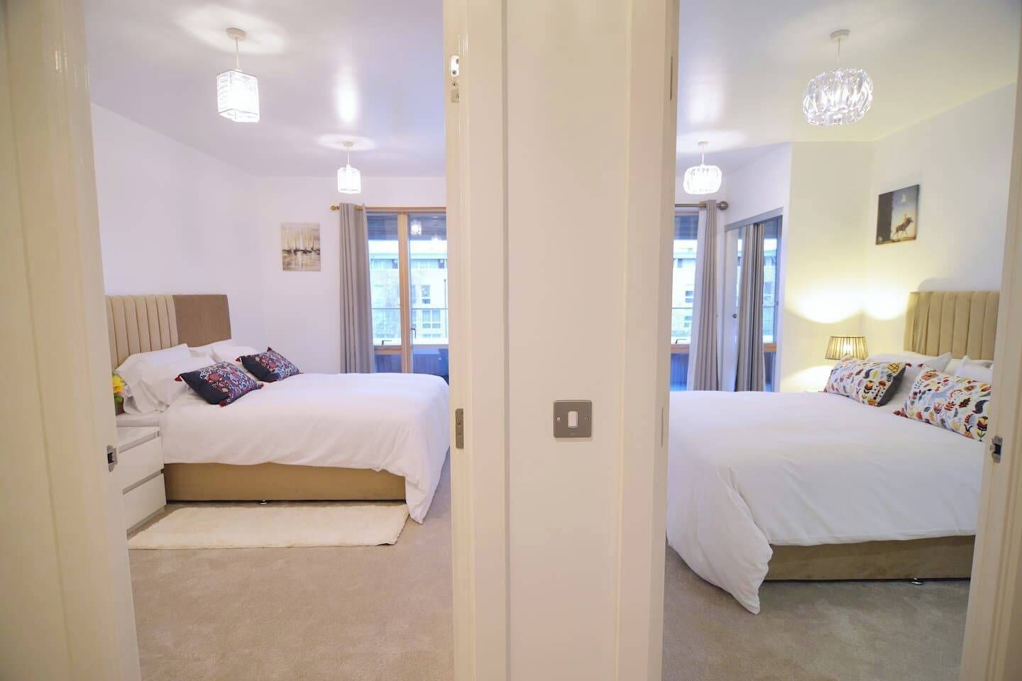 Une vue en miroir d’une chambre d’hôtel avec un lit, une table de chevet et une fenêtre avec des rideaux.