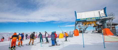 A ski lift station with a clear sky and a group of skiers waiting.