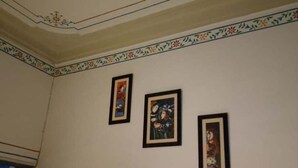 A room with a decorative ceiling and three framed pictures on the wall. - HOTEL ARAWALI UDAIPUR CITY (Udaipur)
