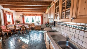 Uma cozinha acolhedora com armários de madeira, pia e um espaço de refeições com cadeiras e mesa.