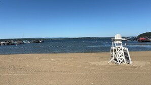 Una playa con una torre de salvavidas y un cielo azul despejado.