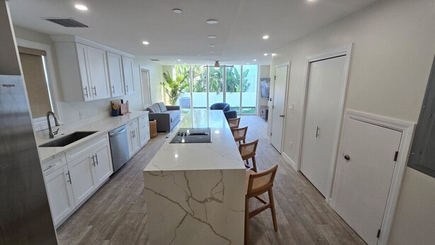 Eine moderne Küche mit einer zentralen Kochinsel, weißen Schränken und einer backsplash in Fischgrätmuster.