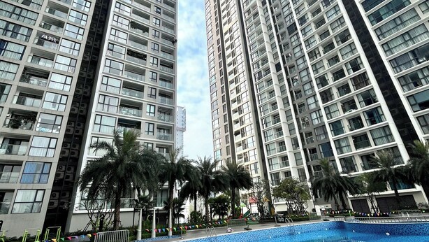 A high-rise residential building with a swimming pool in the foreground. - Hopo Apt - Vinhomes Sky Lake Luxury  (Hanoi)