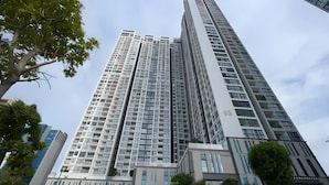 A high-rise building with multiple floors, large windows, and a modern architectural design. - Hopo Apt - Vinhomes Sky Lake Luxury  (Hanoi)