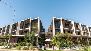 A modern hotel with a central entrance labeled 'JONSON LANE,' featuring a symmetrical facade with balconies and a covered outdoor seating area. - Aurelia Byron- Jonson Lane (Byron Bay)