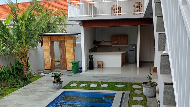 Une maison moderne dotée d’une piscine, d’un espace extérieur couvert et d’une cuisine.