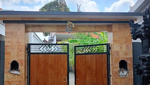 Une entrée fermée par un portail en bois et surmontée d’une arche décorative.