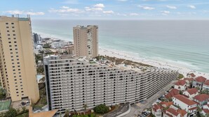 Un hotel grande con fachada curva que da a una playa.