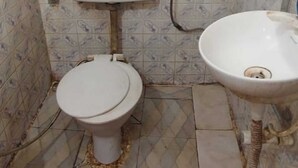 Une salle de bain avec des toilettes, un lavabo et des carreaux décoratifs sur les murs.