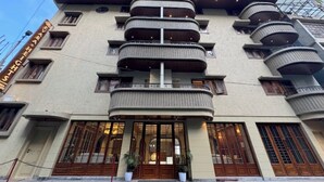 Un hotel de varios pisos con un diseño arquitectónico moderno, con balcones y ventanas amplias.