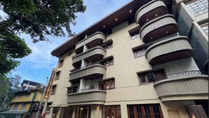 Un hotel de varios pisos con balcones, una entrada a nivel de calle y un letrero que indica que es un hotel.