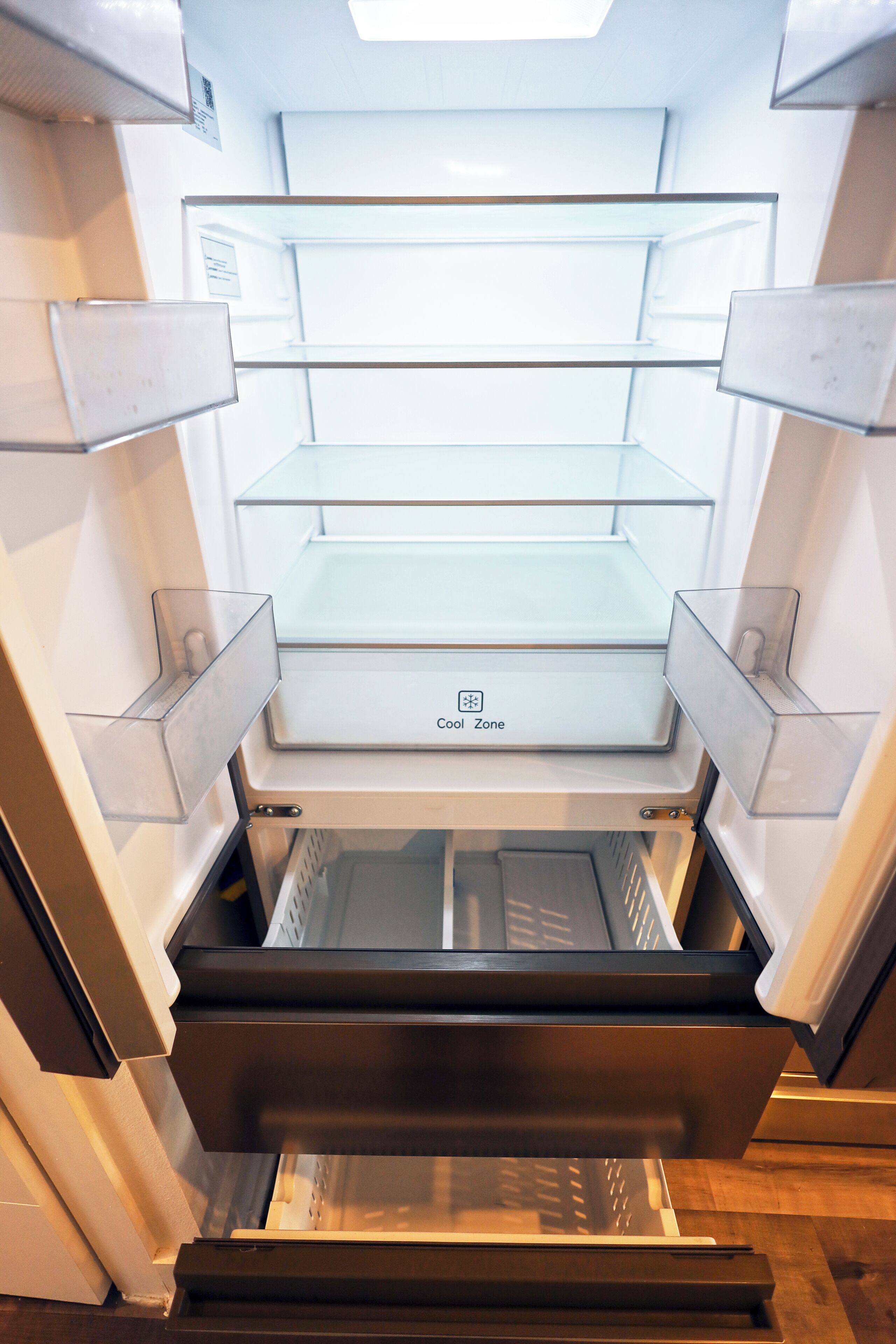 An open refrigerator with multiple shelves and a freezer compartment.