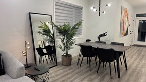 A modern dining area with a dark wooden table, black chairs, and a large mirror. - Family-Friendly Calgary Retreat | Gateway to Banff (Calgary)