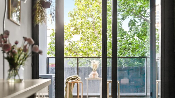 Een modern interieur met een grote schuifglazen deur die leidt naar een balkon.