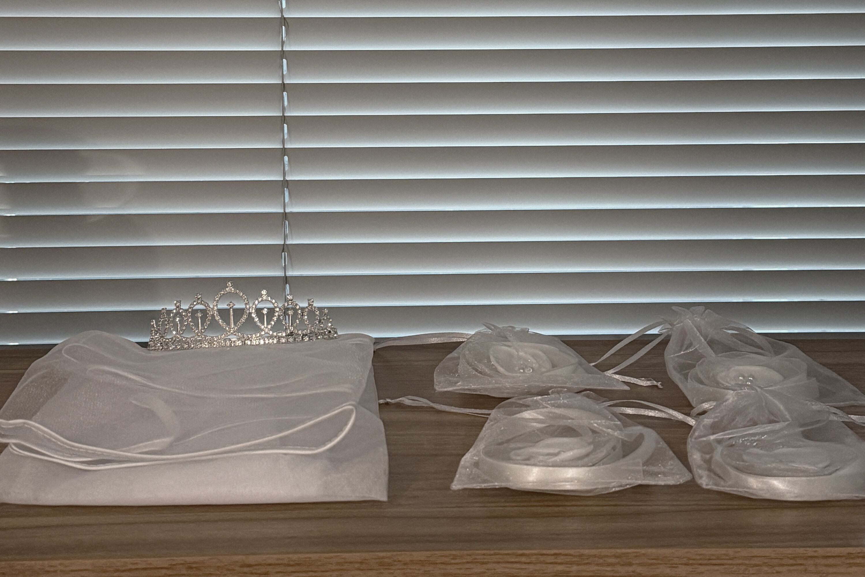 Uma superfície de madeira com um tecido branco e uma tiara.