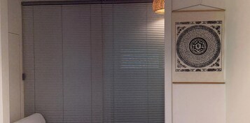 Una habitación con una puerta corredera cerrada, una lámpara colgante y una obra de arte enmarcada en la pared.