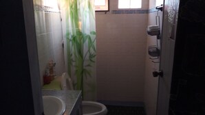 Een badkamer met toilet, wastafel en douche.