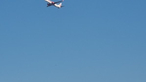 Helderblauwe lucht met een passagiersvliegtuig in de lucht.