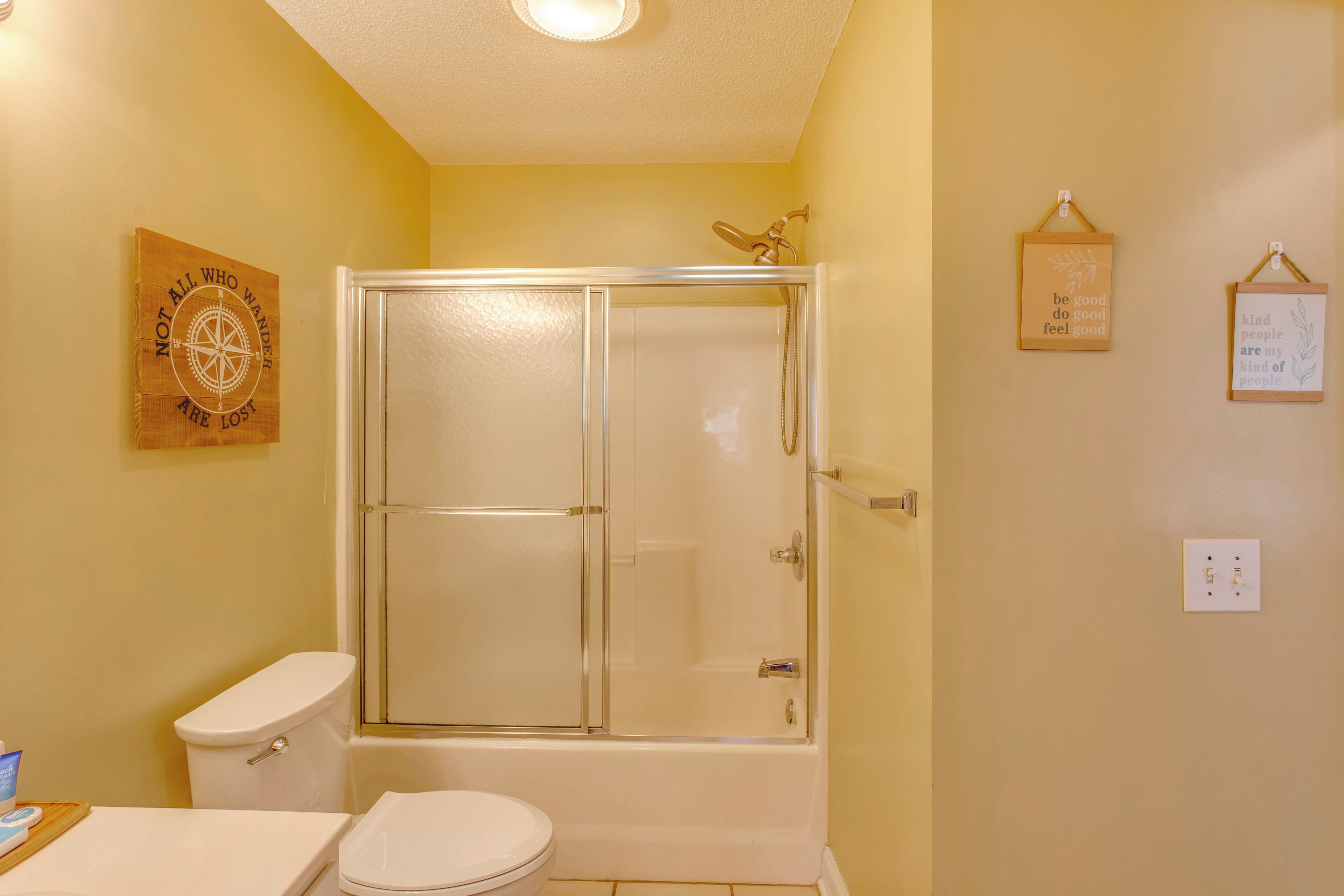 Un baño con ducha de vidrio, inodoro y lavamanos.