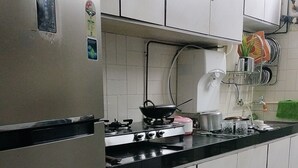 Eine Küche mit Edelstahlgeräten, weißen Schränken und einem gefliesten Boden.