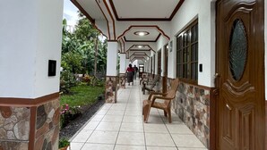 A corridor with a tiled floor, benches, and a heart-shaped rug.