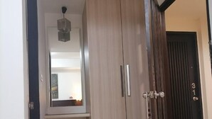 A bedroom with a wardrobe, a mirror, and a door. - AtWhitePatong (Patong)