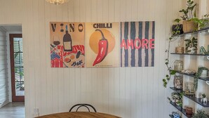 Ein Essbereich mit einem Holztisch, Stühlen und einer Wand mit drei gerahmten Kunstwerken.