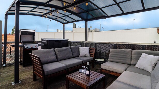 A covered outdoor seating area with a grill, sofas, and a table. - Apartment 'Stadt-Loft' with Private Terrace, Wi-Fi, and Air Conditioning (Nordhausen)