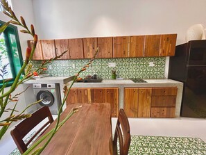 Uma cozinha compacta com armários de madeira, máquina de lavar e painel de fundo padronizado.