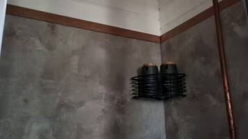 Un angolo doccia con soffitto in legno e tubatura in metallo.
