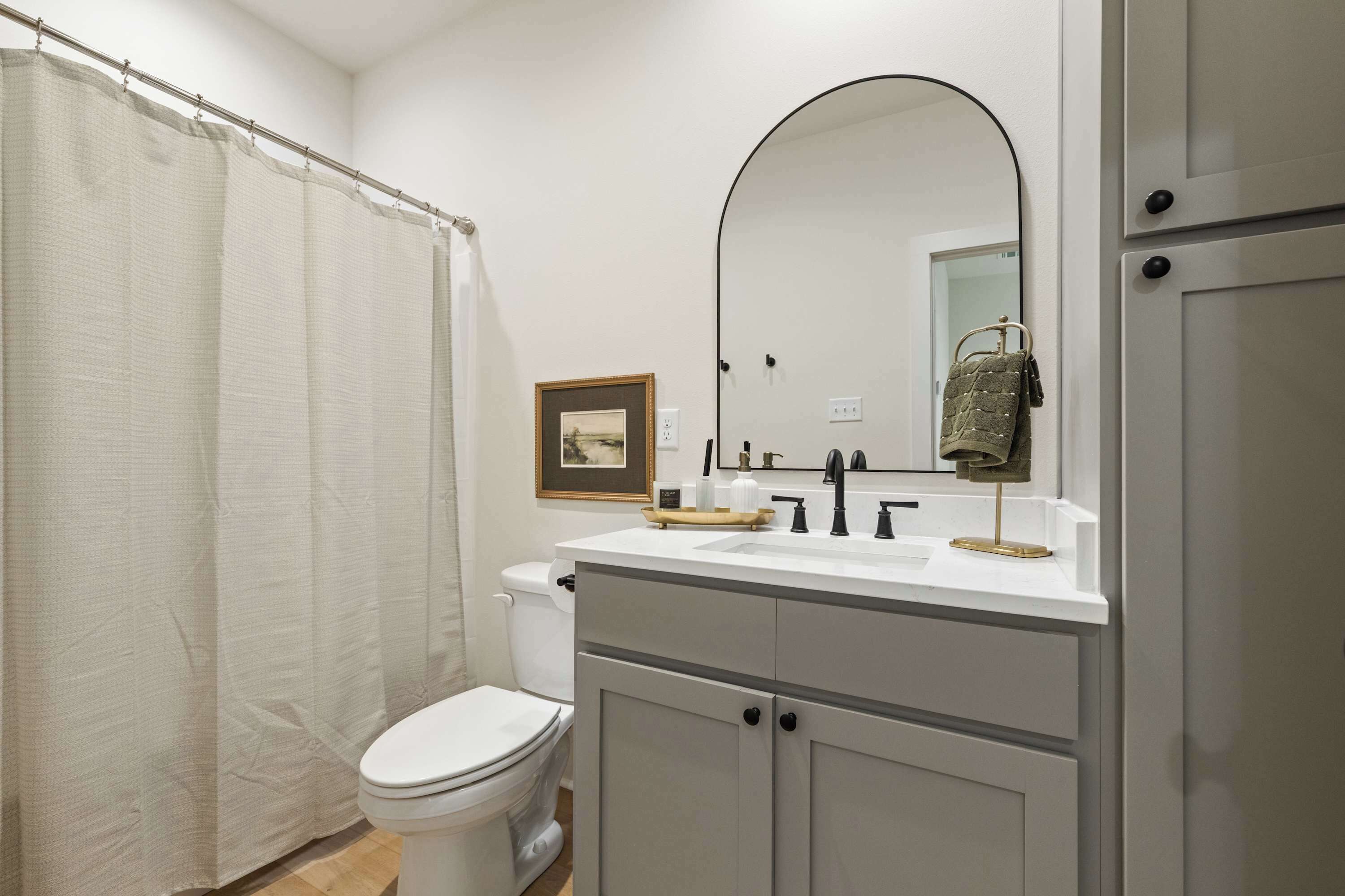 Une salle de bain moderne avec des toilettes, un lavabo et un miroir.