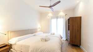 A bedroom with a large bed, bedside tables, a wardrobe, and a ceiling fan. - Room 3A (Doña Mencía)