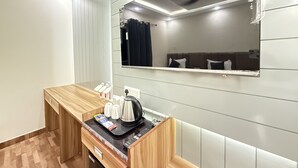 A hotel room with a wooden desk, a mirror, a ceiling fan, and a view of the room's interior. - The Prominence Hotel Greater Noida (Greater Noida)