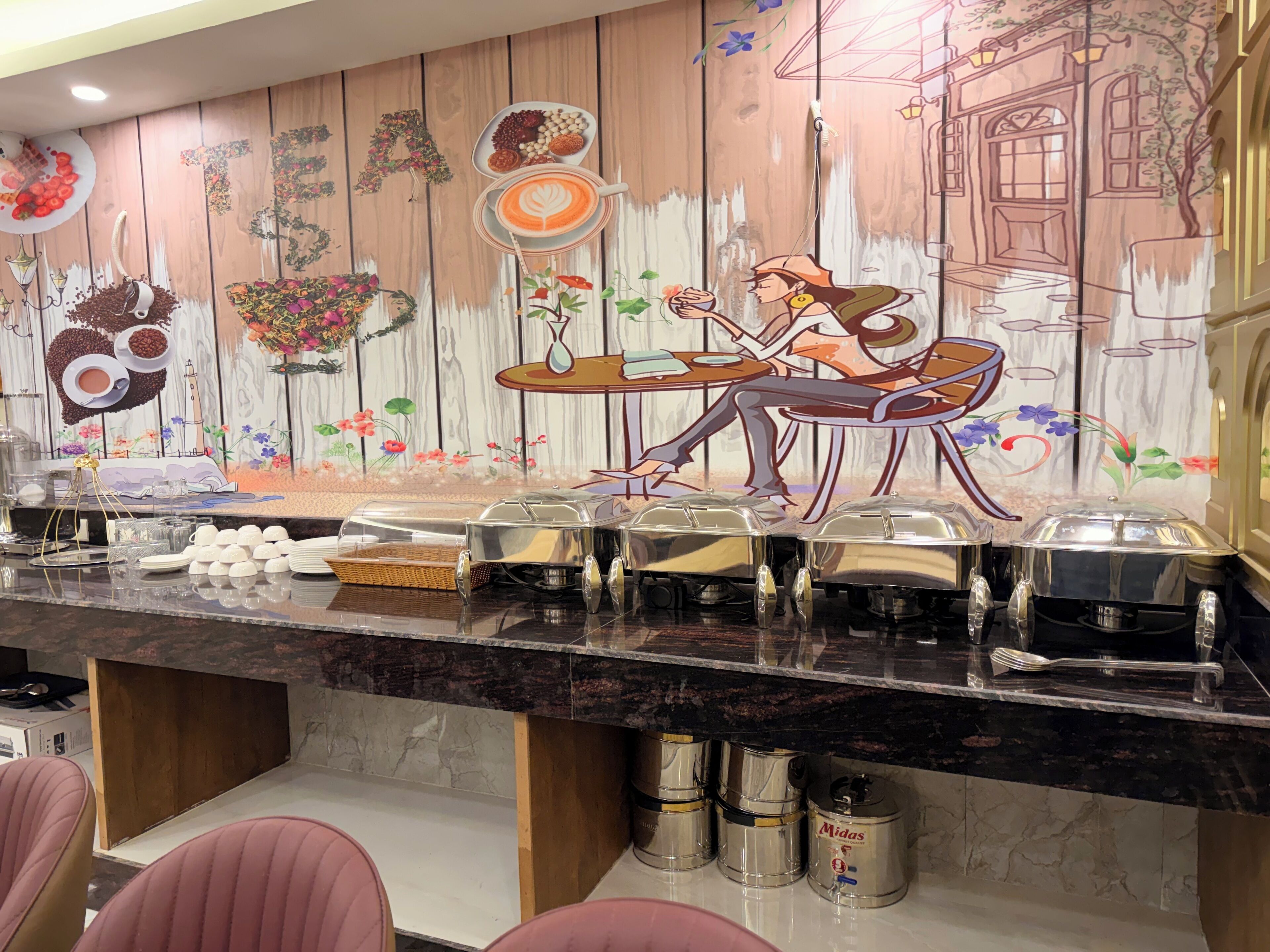 Een toonbank in een restaurant, met een muurschildering, eten en toevoegingen.