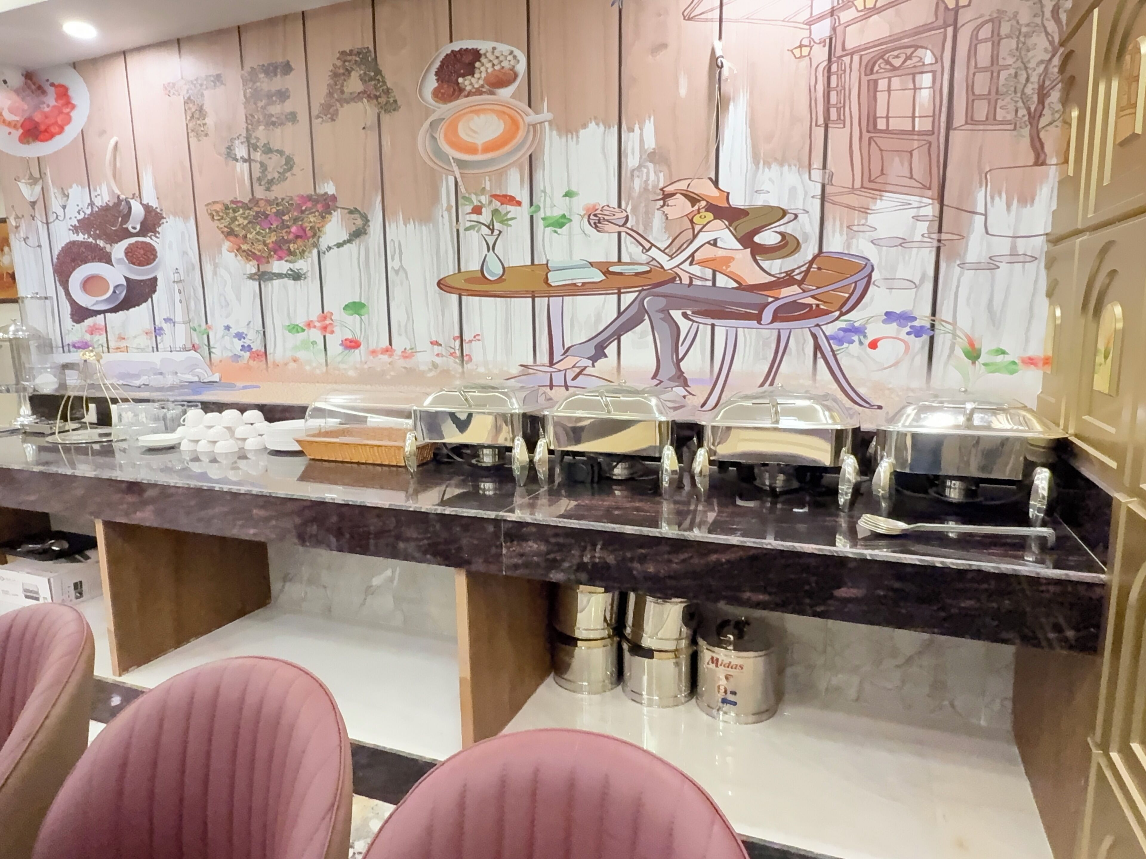 A breakfast bar with food containers and a mural of a woman dining.