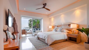 Une chambre moderne avec un grand lit, un ventilateur de plafond, une télévision et une vue sur l’extérieur.