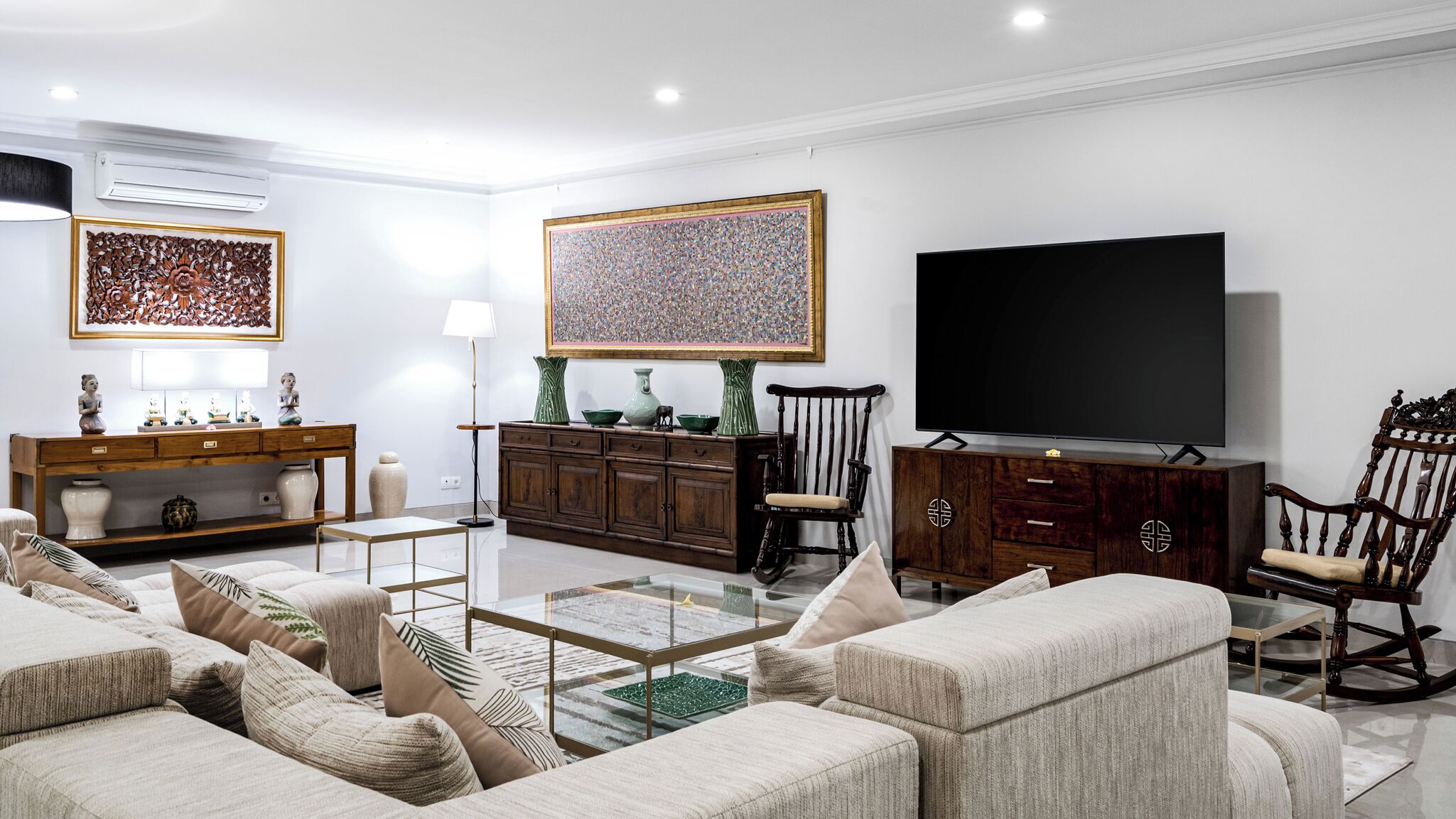 Un salon moderne comprenant un ensemble de canapés, une table basse, un téléviseur et des objets de décoration.