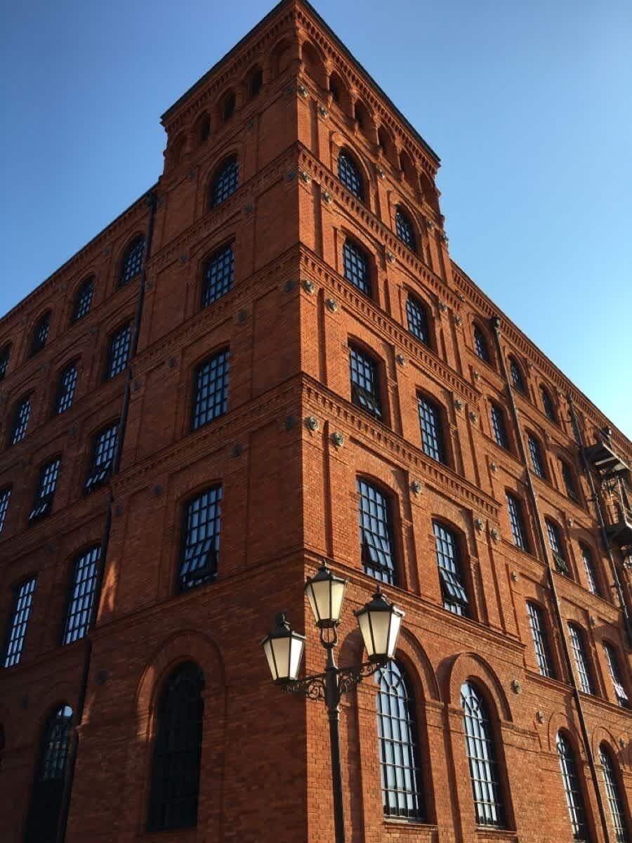 A multi-story brick building with arched windows and a corner entrance.