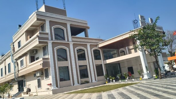 A multi-story building with a modern architectural design, featuring large windows and a flat roof. - The Silk Route Resort (Chanderi)
