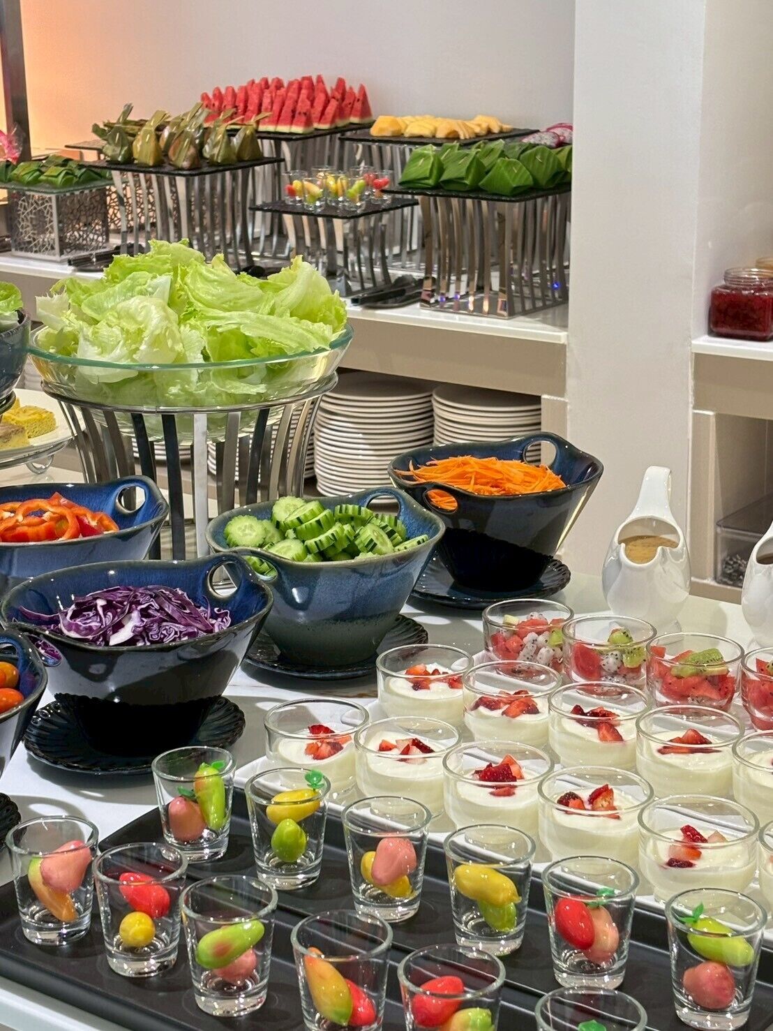 A buffet with various food items including fruits, vegetables, and desserts.