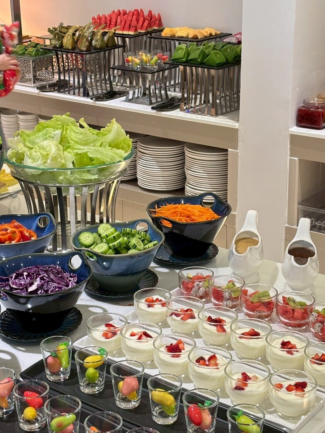 A buffet with various food items including salads, fruits, and desserts.