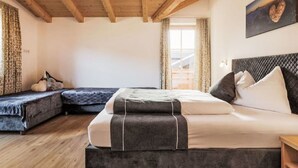 Un dormitorio con cama, sofá y ventana.