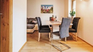 Un comedor con una mesa de madera, sillas y un cuadro en la pared.