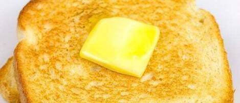 A stack of toasted bread with butter on a white plate.