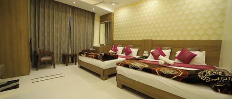 A hotel room with two beds, a ceiling fan, and a large window with curtains.